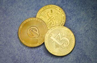 Тестирование Криптопроектов — Заработок для Технических Специалистов three gold coins sitting on top of a blue surface
